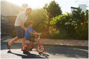 Father teaches his son how ride a bike