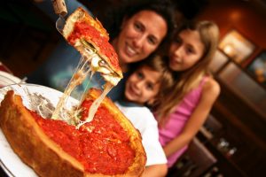 Cute family enjoying a deep dish Chicago Style Pizza.