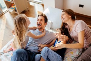 Family Playing In Bed